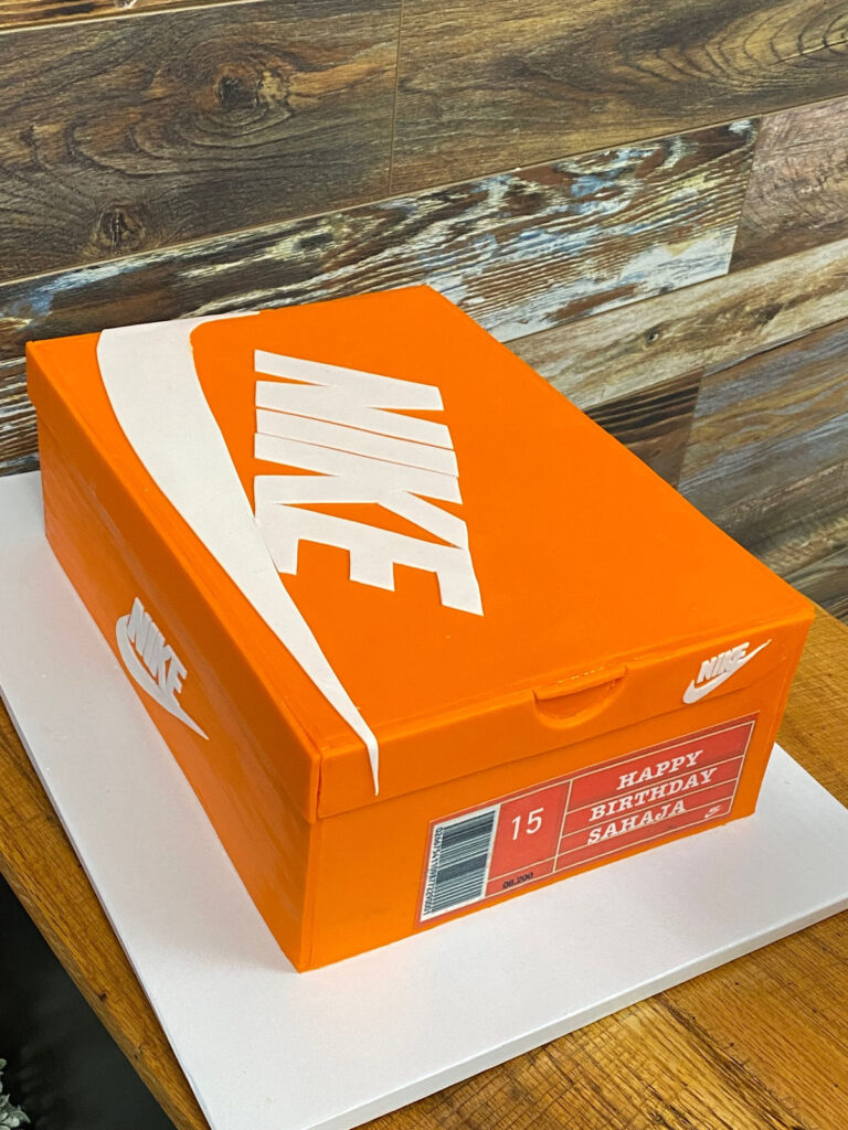 Sculpted cake shaped like an orange trainer shoe box