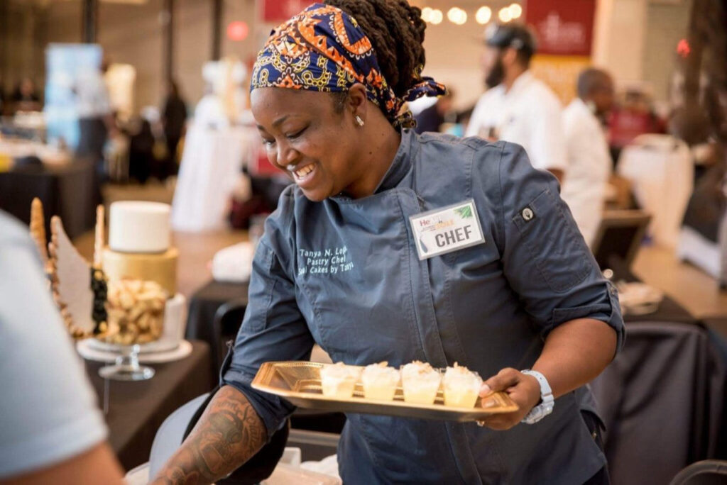 Tanya serving a tray of desserts at an event